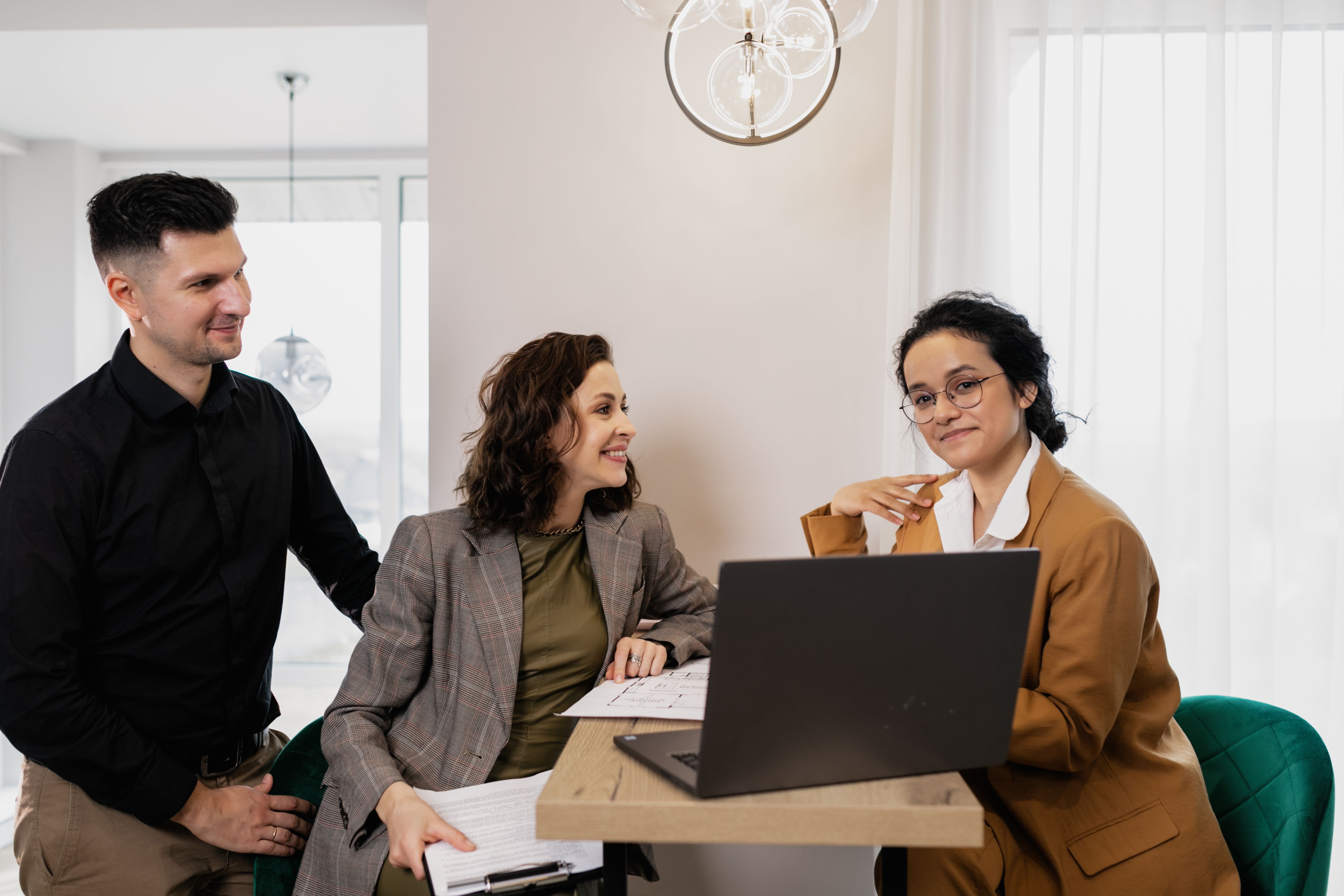 Équipe échangeant autour d’un ordinateur pour structurer une transformation d’entreprise