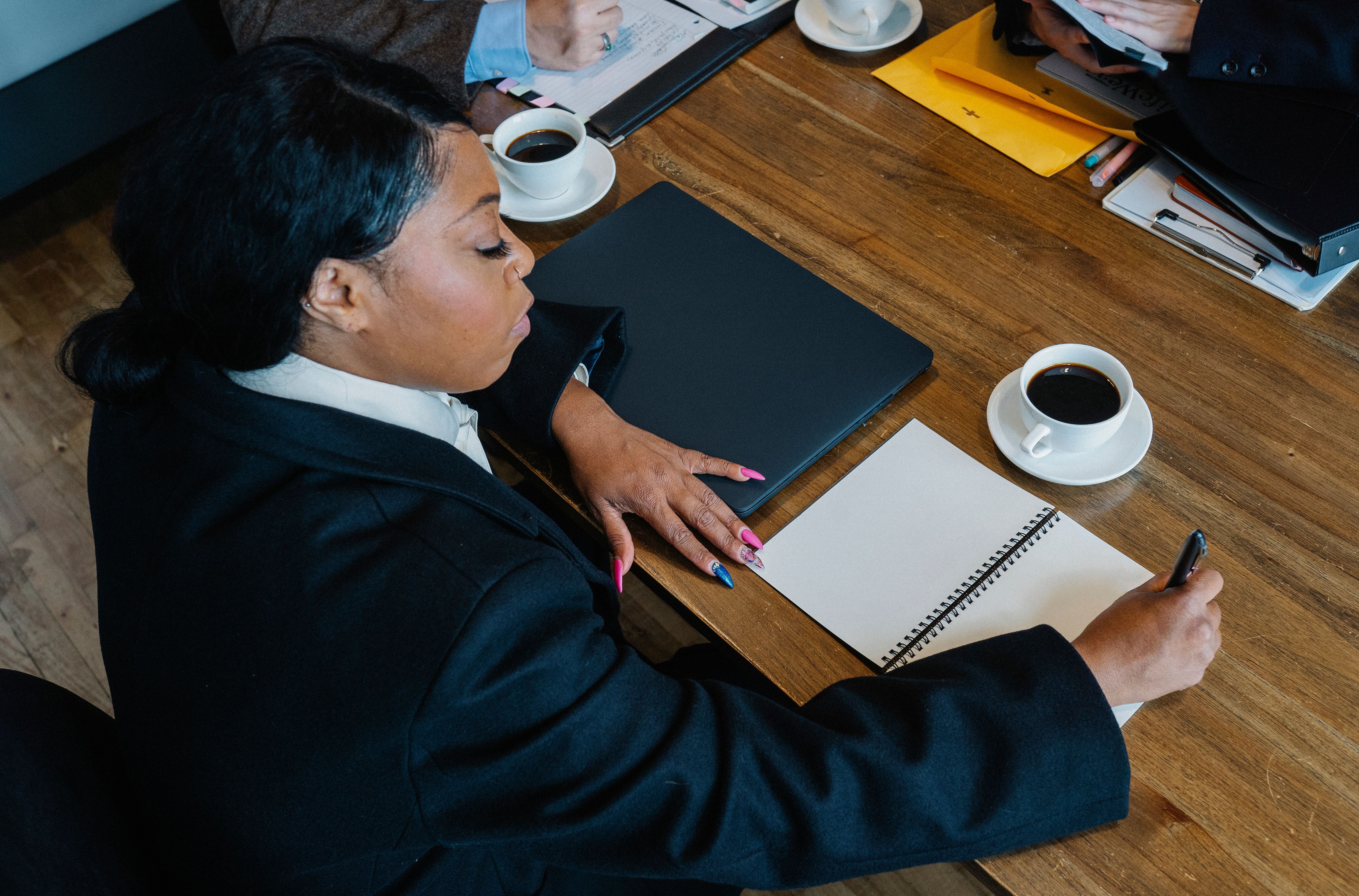 Professionnelle prenant des notes pendant une réunion de travail