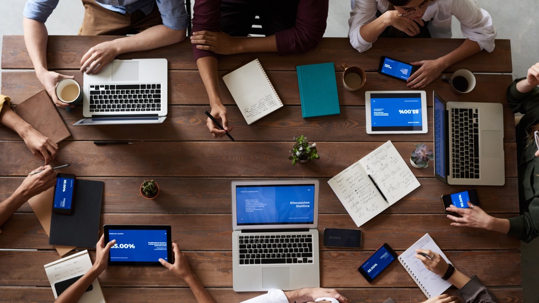 Equipo de trabajo revisando información de la empresa en computadoras y tabletas.