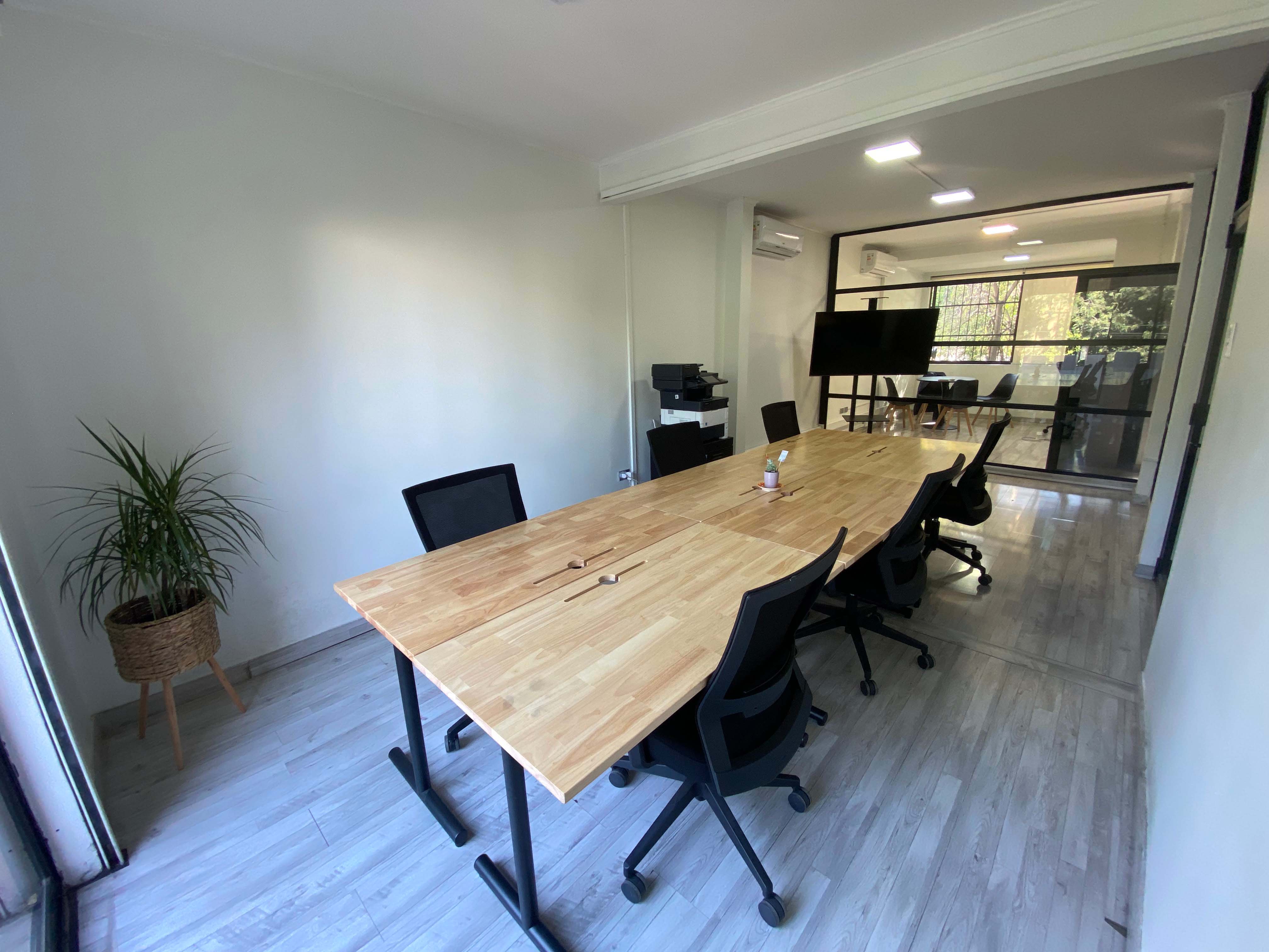 Sala Momentum, sala privada con mesa central y sillas para reuniones de equipo.