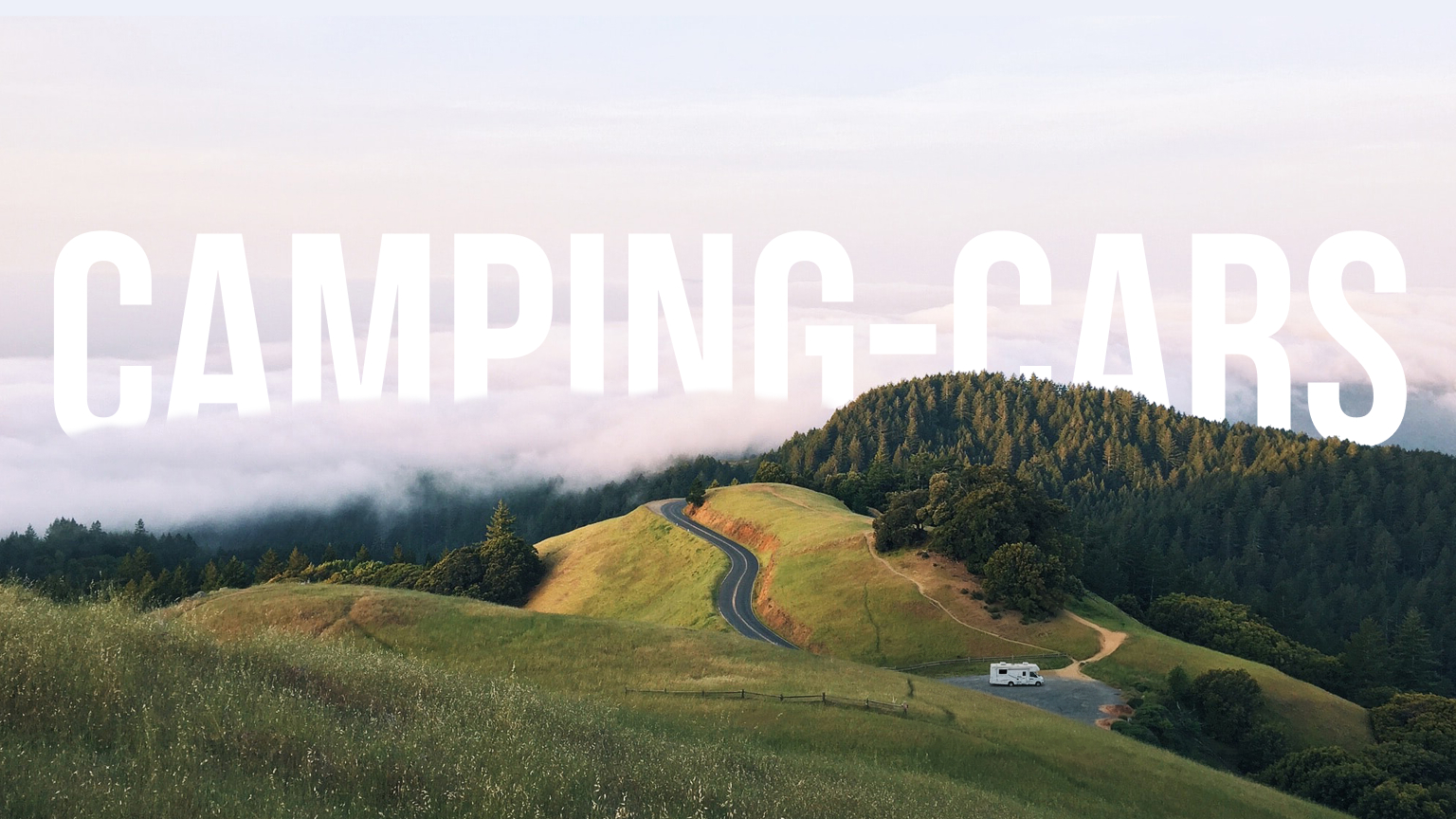 Camping-car évoluant au loin sur une route sinueuse d'un un massif forestiers