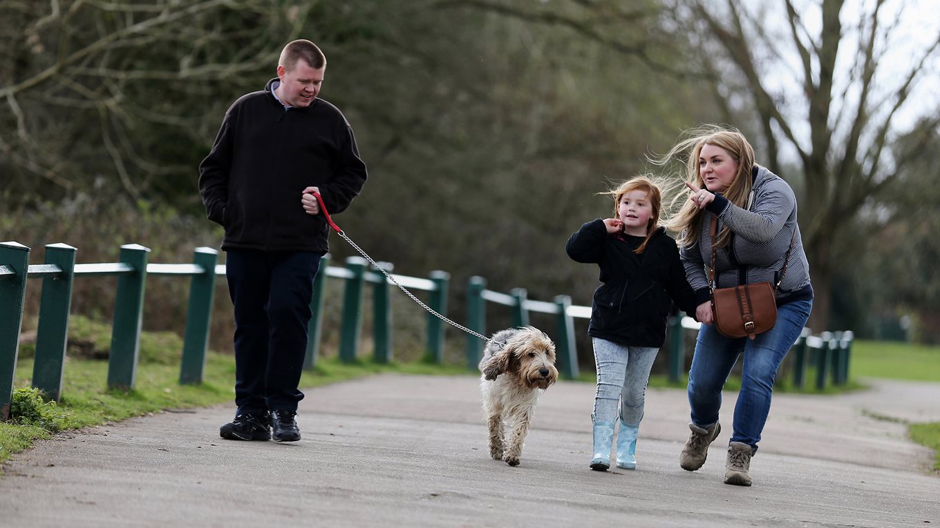 A family walking in the park with dog