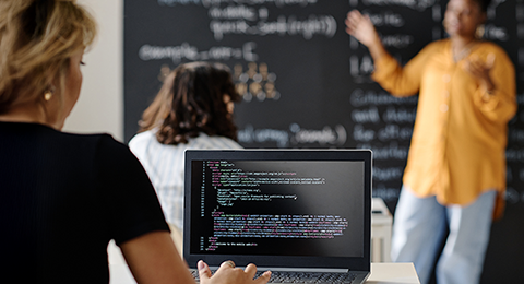 Utilizadora de computador portátil numa sala de aula