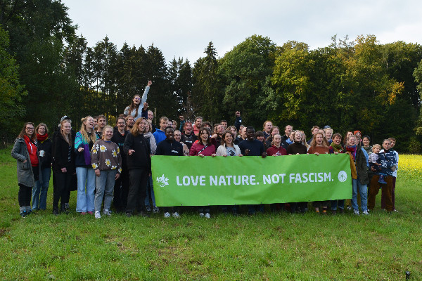 Menschen hinter einem Transparent mit der Aufschrift: Love NAture.NotFascism
