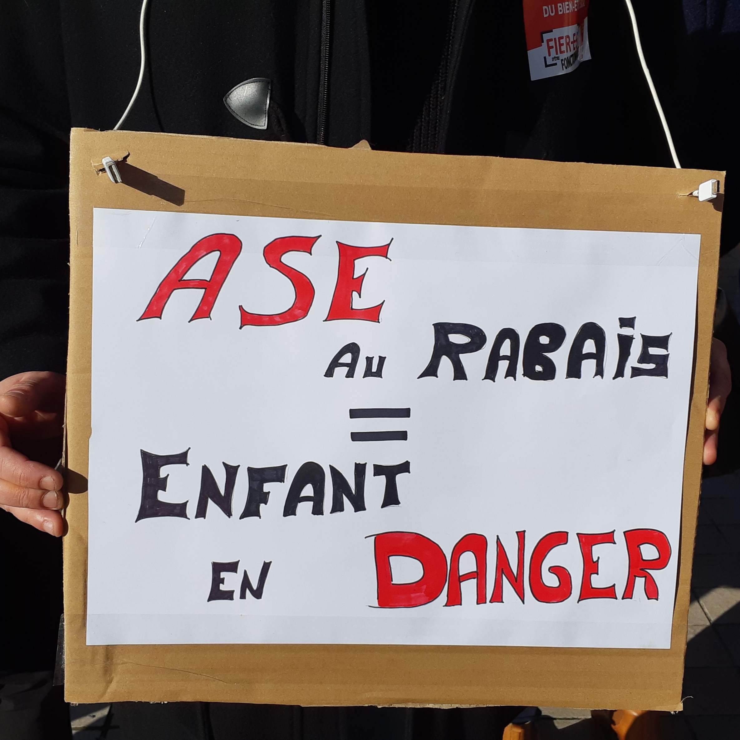 Pancarte lors d'une manifestation : ASE au rabais = enfant en danger