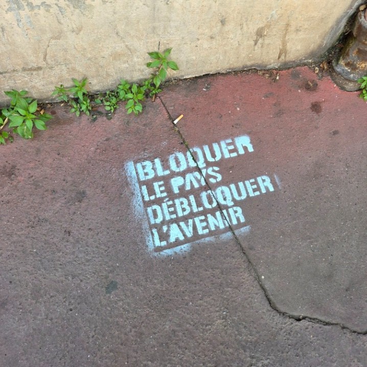Slogan "Bloquer le pays, débloquer l'avenir" sur un trottoir de Montreuil