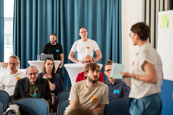 Sitzende Menschen und Moderatorin