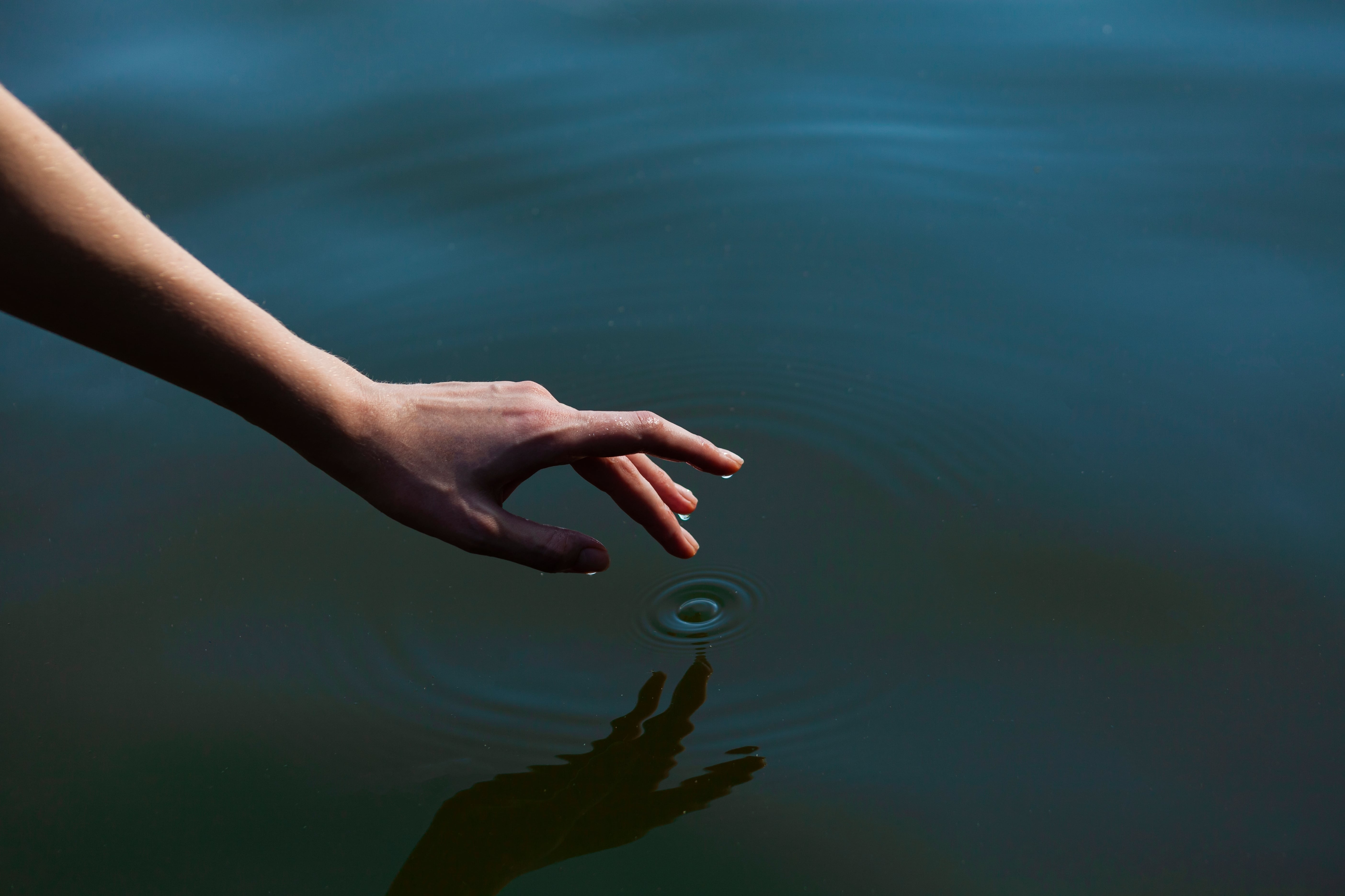 Finger tippt in Wasser