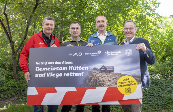 4 Männer hinter Kampagnen-Plakat