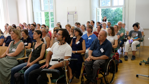 Menschen sitzen in Reihen und schauen nach vorne