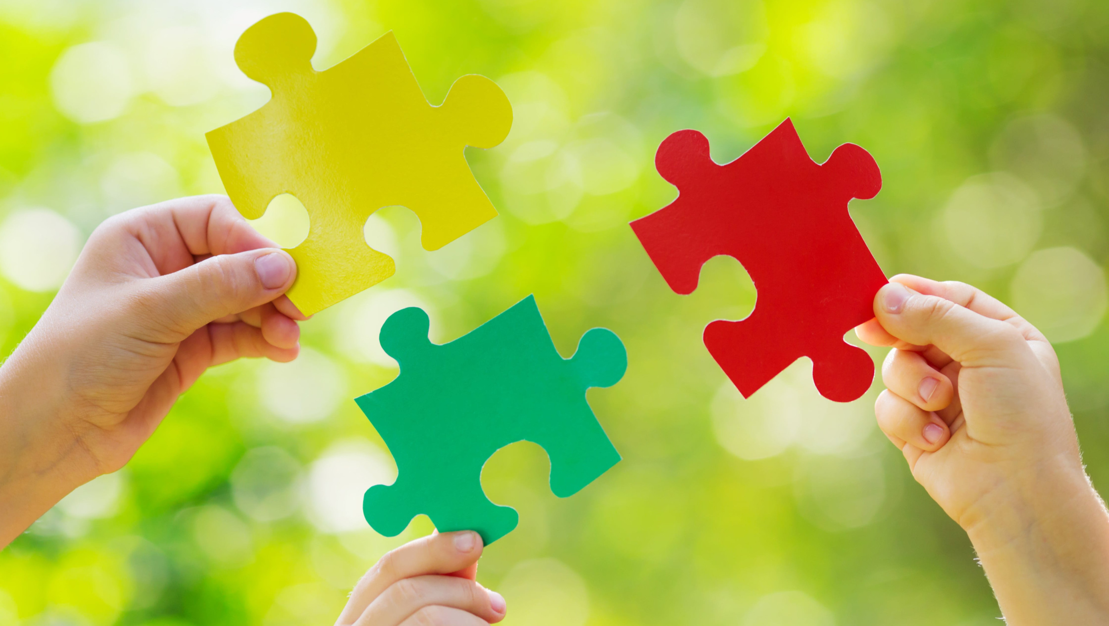 3 Hände halten Puzzleteile