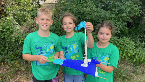 Drei Kinder mit kleinem Boot in der Hand