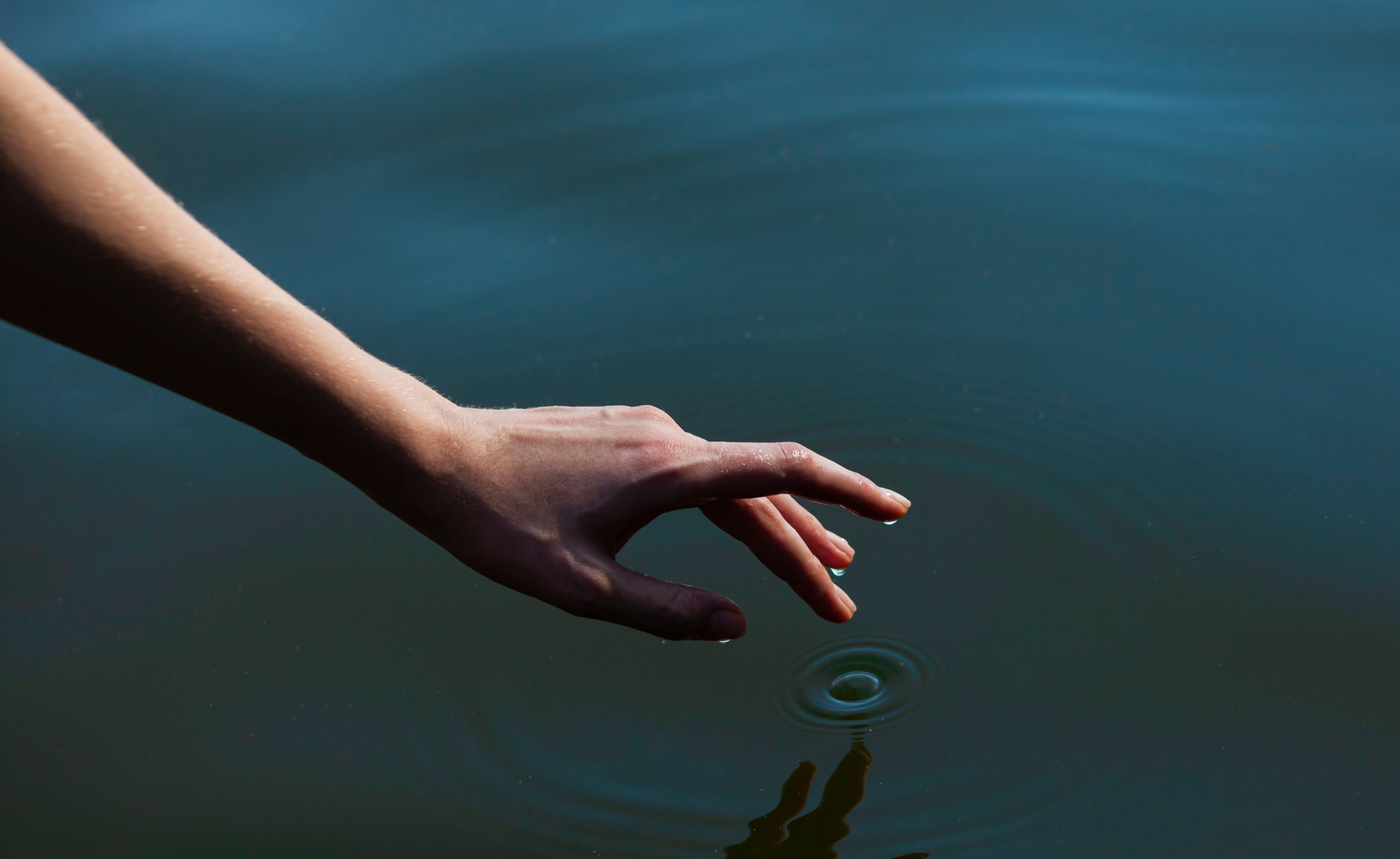Finger tippt ins Wasser