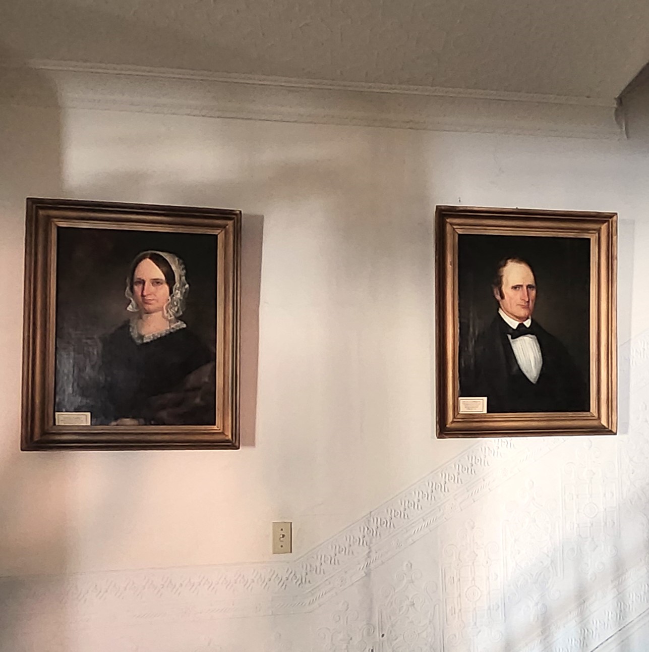 Portraits of Catherine Miles Green (left) and Joseph Green (right) on a wall inside the Miles-Humes House at the bottom of the main staircase.