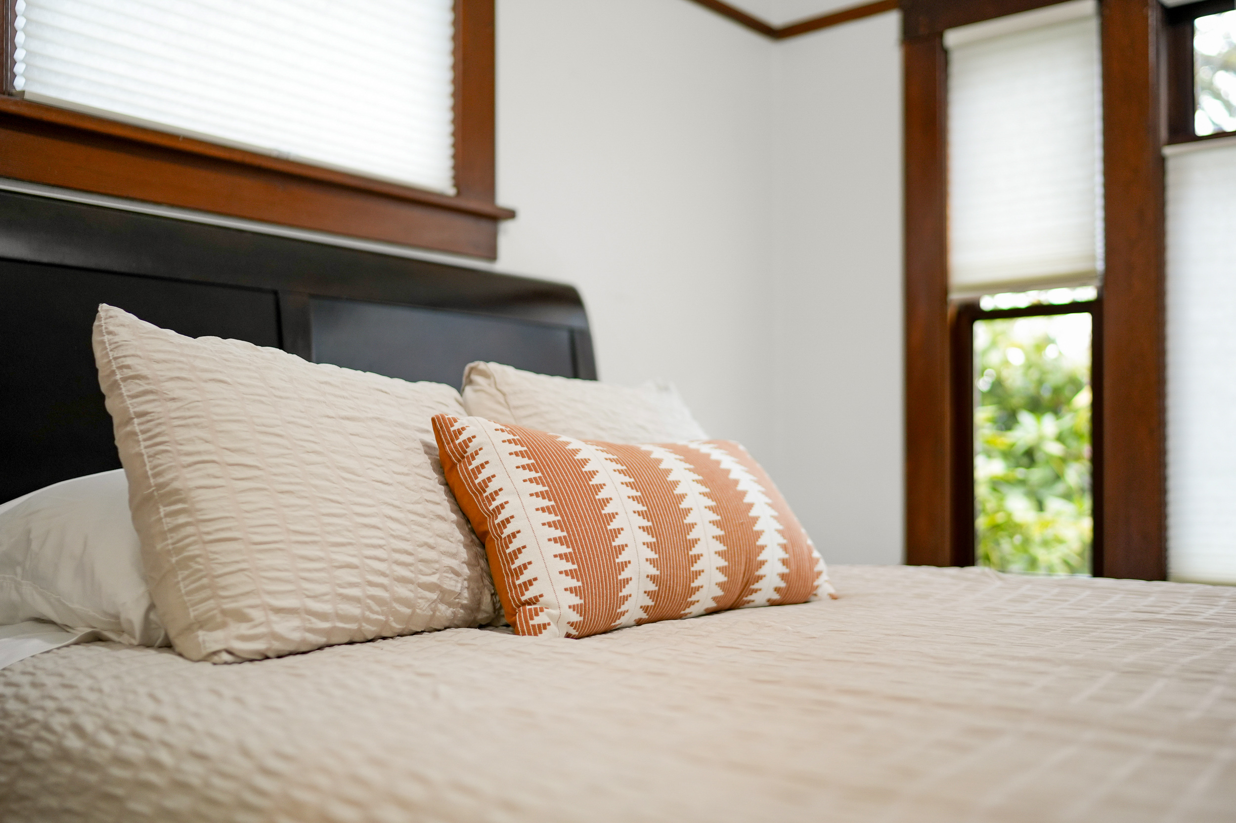 Layered white pillows and green bedding prepared for vacation rental guests