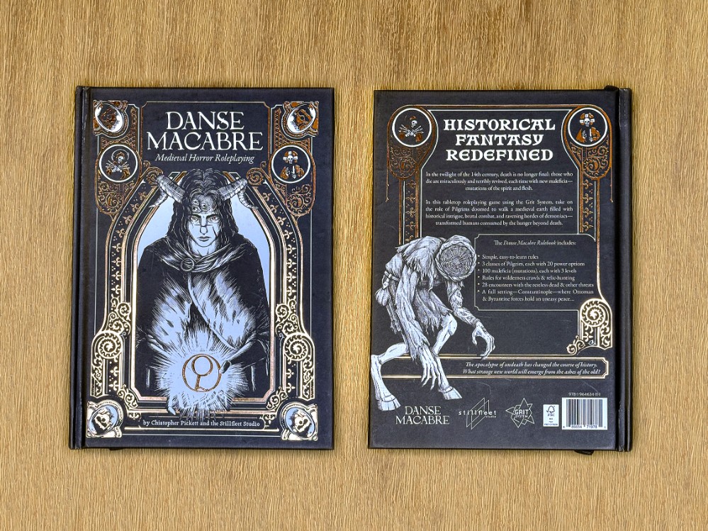Bronze foil on the front and back covers of the Danse Macabre Rulebook Deluxe, with art by Christopher Pickett and design by Anthony Grasso